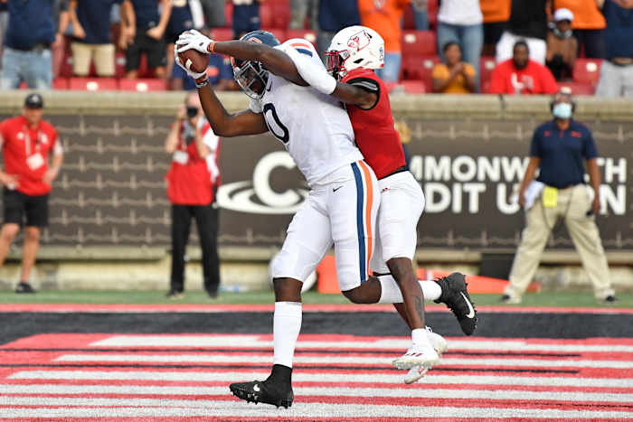 Oct 9, 2021; Louisville, Kentucky, USA; Virginia Cavaliers tight end Jelani Woods (0) pulls in a touchdown pass under the pressure of Louisville Cardinals defensive back Kei'Trel Clark (13) during the second half at Cardinal Stadium. Virginia defeated Louisville 34-33. Mandatory Credit: Jamie Rhodes-USA TODAY Sports