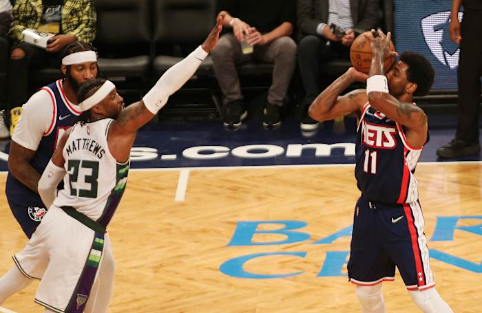 Brooklyn Nets guard Kyrie Irving (11) takes a shot against Milwaukee Bucks guard Wesley Matthews (23) during the second half at Barclays Center.