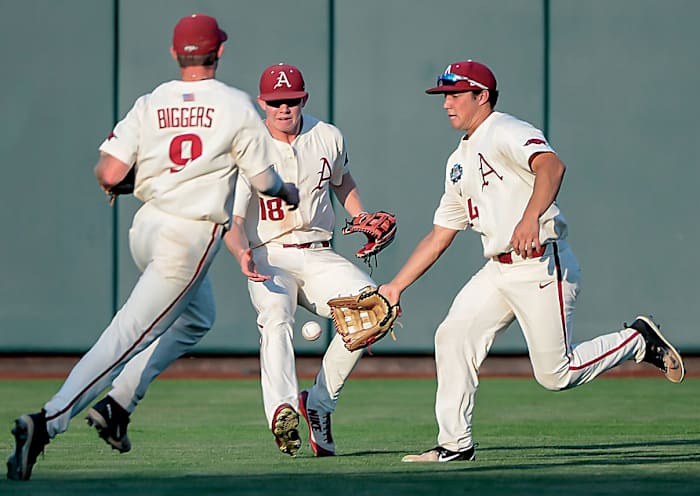 Arkansas Razorbacks shortstop Jax Biggers (9) and left fielder Heston Kjerstad (18) and center fielder Dominic Fletcher (24) converge on a ball in the game against the Oregon State Beavers in game 3 of the College World Series at TD Ameritrade Park. Arkansas dropped a similar pop-up in the previous game that would have clinched the championship.