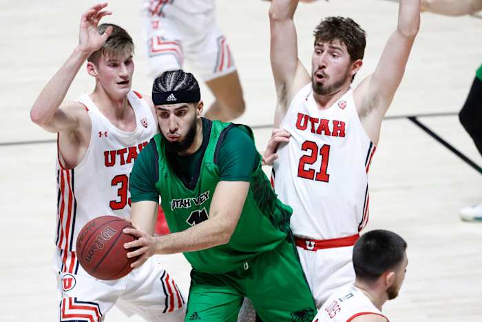 Utah Valley Wolverines center Fardaws Aimaq (11) looks to pass against Utah Utes center Branden Carlson (35), left and forward Riley Battin (21) in the first half at the Jon M. Huntsman Center.