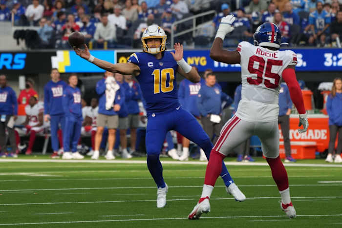 Dec 12, 2021; Inglewood, California, USA; Los Angeles Chargers quarterback Justin Herbert (10) throws the ball under pressure from New York Giants line backer Quincy Roche (95) in the first half at SoFi Stadium.