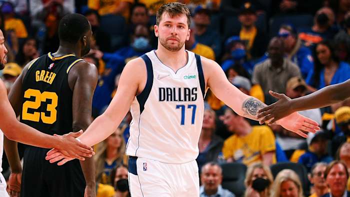 Dallas Mavericks guard Luka Doncic (center) high-fives guard Jalen Brunson after a play against the Golden State Warriors.