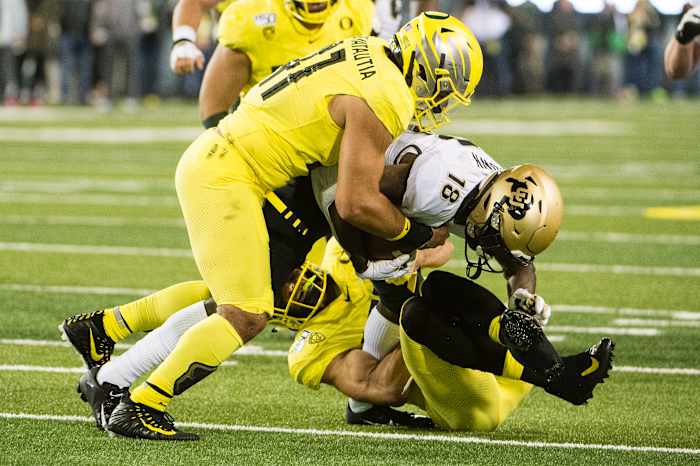 Isaac Slade-Matautia tackles wide receiver Tony Brown in a game against the Colorado Buffaloes at Autzen Stadium.