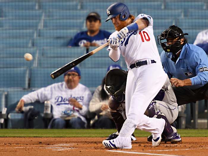 Apr 14, 2021; Los Angeles, California, USA; Los Angeles Dodgers third baseman Justin Turner (10) singles in a run in the first inning of the game against the Colorado Rockies at Dodger Stadium.