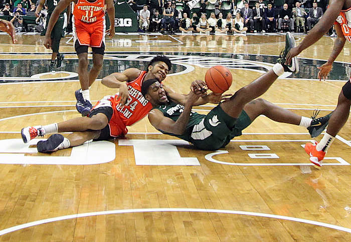 Illinois Fighting Illini center Jermaine Hamlin (34) and Michigan State Spartans forward Aaron Henry (11) fight for a loose ball during the second half of a 2020 game at the Breslin Center.