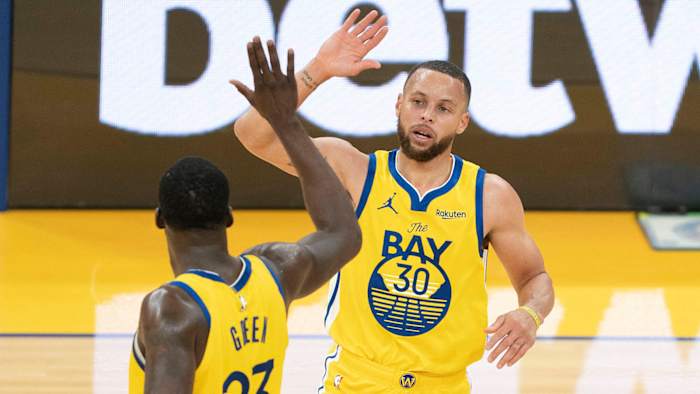Golden State Warriors guard Stephen Curry celebrates with forward Draymond Green.