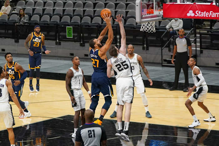 Rudy Gobert (27) scores over Jakob Poeltl (25)