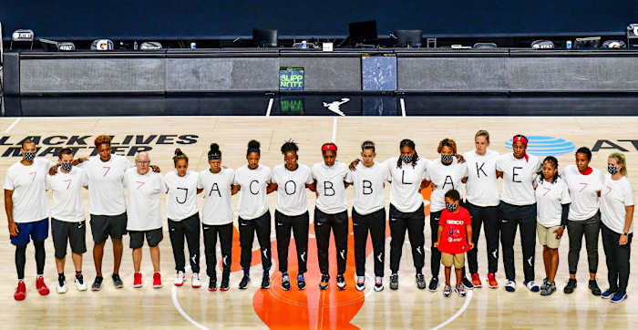 The Mystics players spelling out JACOB BLAKE on their T-shirts