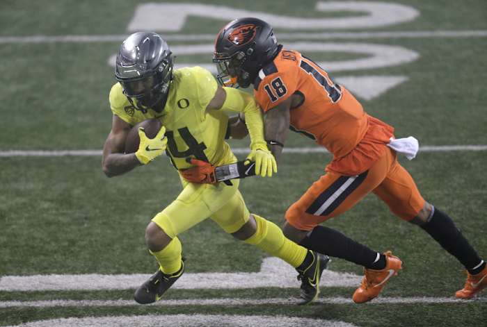 Kris Hutson (14) fights for extra yards against Oregon State's Alex Austin (18) at Reser Stadium.