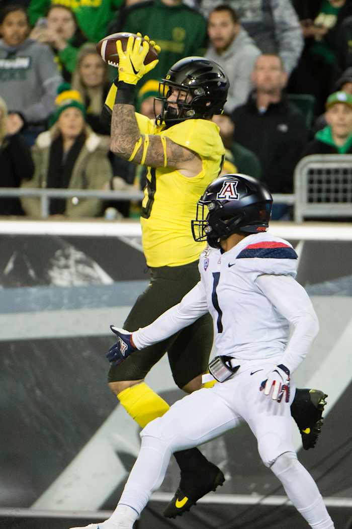 Spencer Webb hauls in a touchdown pass while linebacker Tony Fields defends in a game against the Arizona Wildcats on November 16, 2019. Oregon would win the game 34-6.