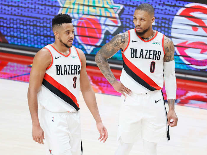 Portland Trail Blazers shooting guard CJ McCollum (3) and point guard Damian Lillard (0) walk back to the court after a timeout during the second half of game three in the first round