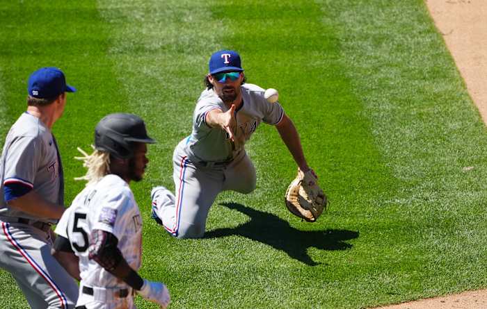 Jun 3, 2021; Denver, Colorado, USA; Texas Rangers infielder Charlie Culberson (2) fields the ball at relief pitcher Wes Benjamin (63) in the fifth inning against the Colorado Rockies at Coors Field.