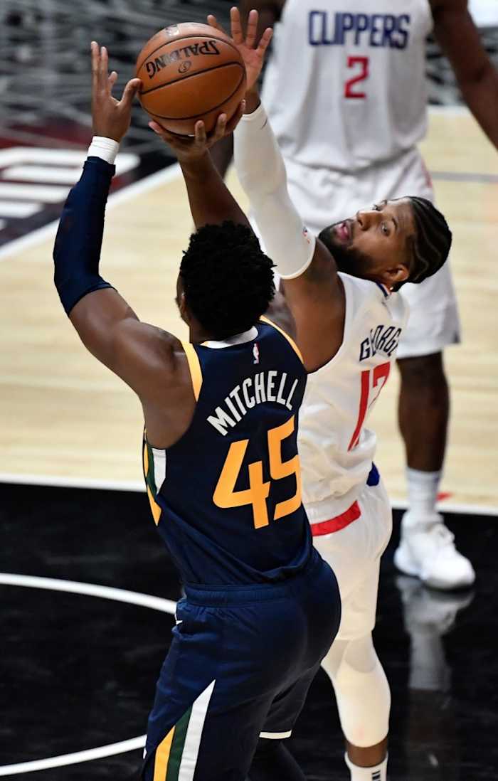 Donovan Mitchell (45) scores over Paul George (13) and the Los Angeles Clippers