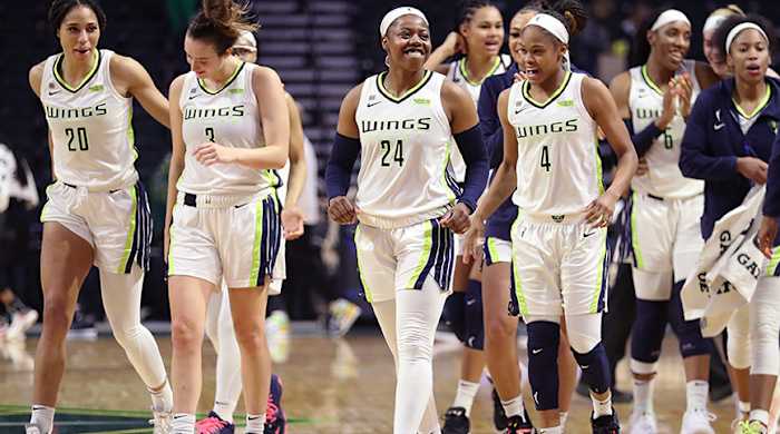 Arike Ogunbowale and the Dallas Wings smile on the court