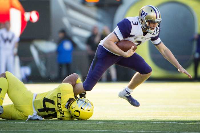 Isaac Slade-Matautia (41) clutches onto Washington quarterback Jake Browning's (3) leg for a tackle for loss.