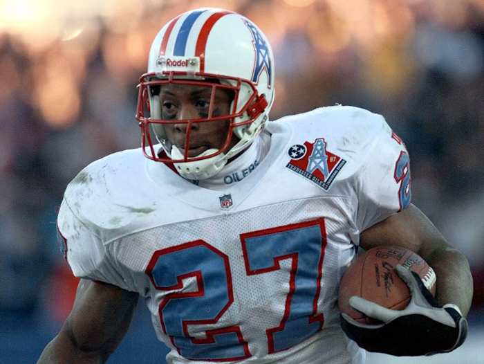 Eddie George runs with the ball while with the NFL's Oilers