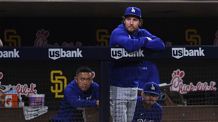 Jun 22, 2021; San Diego, California, USA; Los Angeles Dodgers starting pitcher Trevor Bauer (top) looks on from the dugout during the fifth inning against the San Diego Padres at Petco Park.