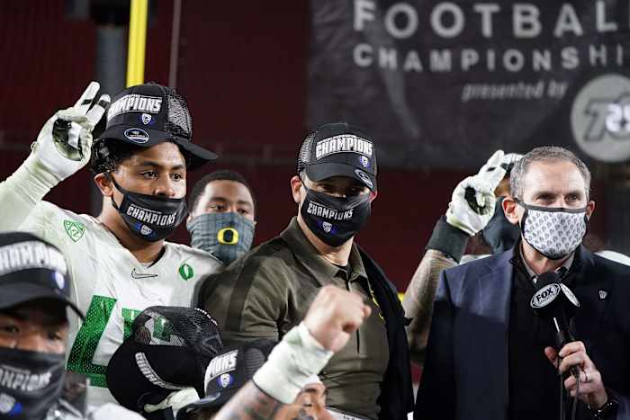 Mario Cristobal stands next to former Pac-12 commissioner Larry Scott after winning the 2020 conference title in Los Angeles.