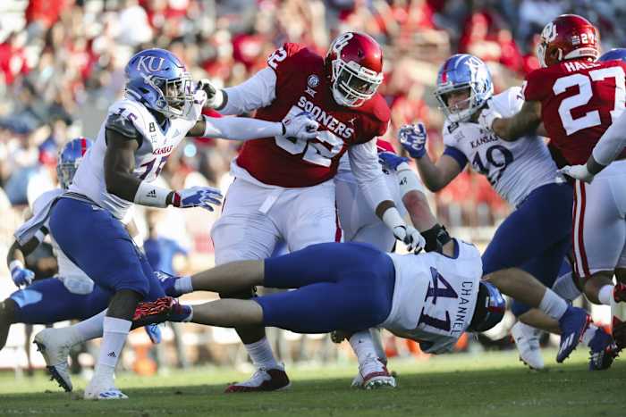 Nov 7, 2020; Norman, Oklahoma, USA; Oklahoma Sooners offensive lineman Tyrese Robinson (52) blocks Kansas Jayhawks linebacker Kyron Johnson (15) and linebacker Nick Channel (41) during the first half against the Kansas Jayhawks at Gaylord Family-Oklahoma Memorial Stadium.