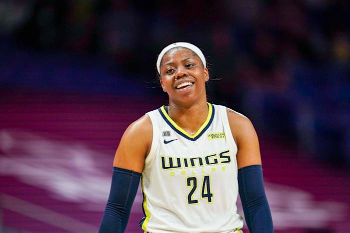 Arike Ogunbowale smiling in a white jersey