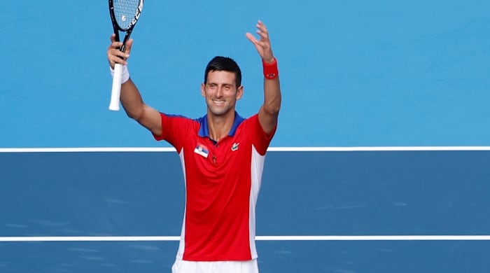 Novak Djokovic holding up a tennis racket