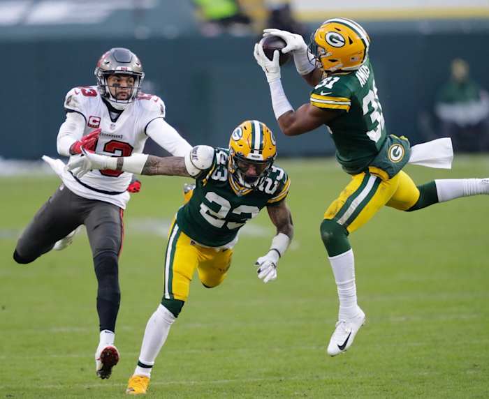 Green Bay Packers safety Adrian Amos (31) intercepts a pass intended for Buccaneers receiver Mike Evans (13) as cornerback Jaire Alexander (23) helps on the play. © Dan Powers/USA TODAY NETWORK-Wisconsin via Imagn Content Services, LLC