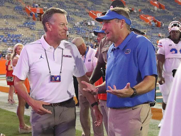 Scott Stricklin talks with Dan Mullen after a Gators win