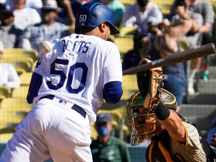 Sep 12, 2021; Los Angeles, California, USA; Los Angeles Dodgers center fielder Mookie Betts (50) gets hit in the back by a pitch from San Diego Padres reliever Austin Adams (not pictured) in the eighth inning at Dodger Stadium.