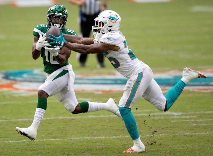 Xavien Howard reaches to grab an interception in front of Jets receiver Jeff Smith during a 2020 game