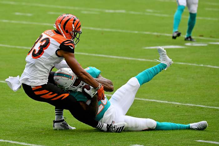 Xavien Howard holds on to an interception on the ground as Bengals receiver Tyler Boyd pulls at the ball during a game in 2020