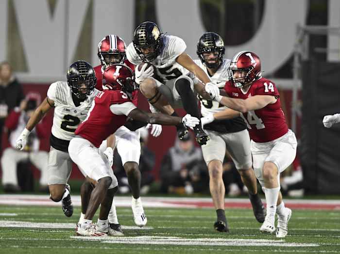 Purdue Boilermakers running back Devin Mockobee (45) jumps between Indiana Hoosiers defensive back Tiawan Mullen (3) and linebacker Kaiden Turner (14) during the second half at Memorial Stadium.