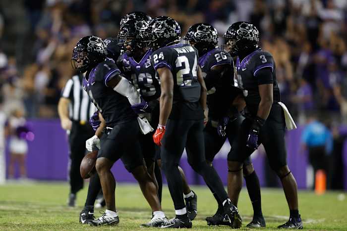 TCU Horned frog football players react in a huddle after an interception against the Kansas State Wildcats