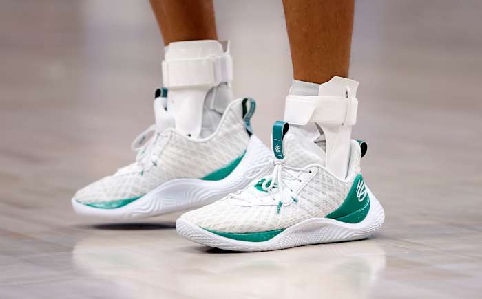 View of white and green Curry shoes.