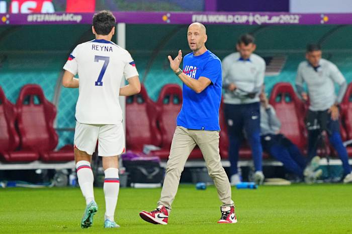 Gregg Berhalter talks with midfielder Giovanni Reyna.