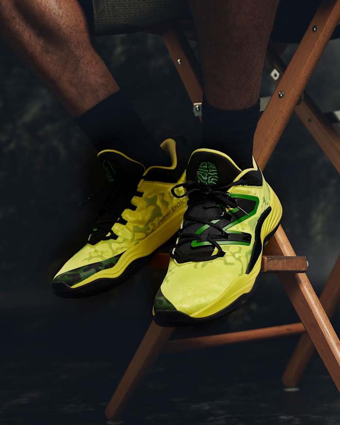 View of yellow, green, and black New Balance shoes.