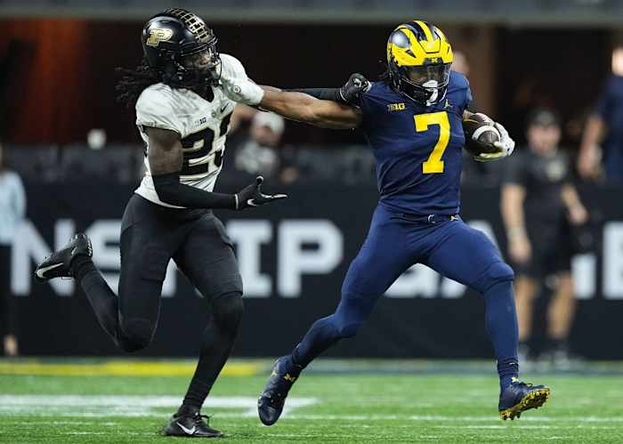 Michigan Wolverines running back Donovan Edwards (7) rushes the ball against Purdue Boilermakers cornerback Cory Trice (23) during the Big Ten football championship on Saturday, Dec. 3, 2022 at Lucas Oil Stadium in Indianapolis. Michigan Wolverines defeated the Purdue Boilermakers, 43-22.