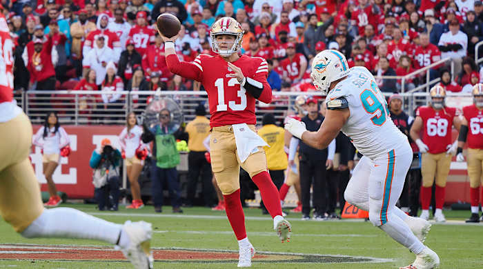 Brock Purdy throws a pass off his back foot in a 49ers win over the Dolphins.