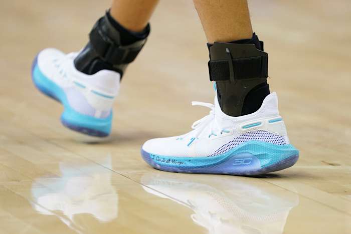 View of white and blue Under Amour shoes.