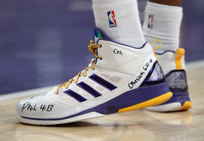 View of white and purple adidas shoes.