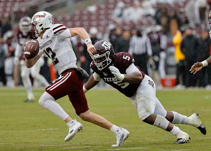 COLLEGE STATION, TEXAS - NOVEMBER 19: Brady Olson #12 of the Massachusetts Minutemen scrambles top avoid being tackled by Shemar Turner #5 of the Texas A&M Aggies during the fourth quarter at Kyle Field on November 19, 2022 in College Station, Texas. (Photo by Bob Levey/Getty Images)