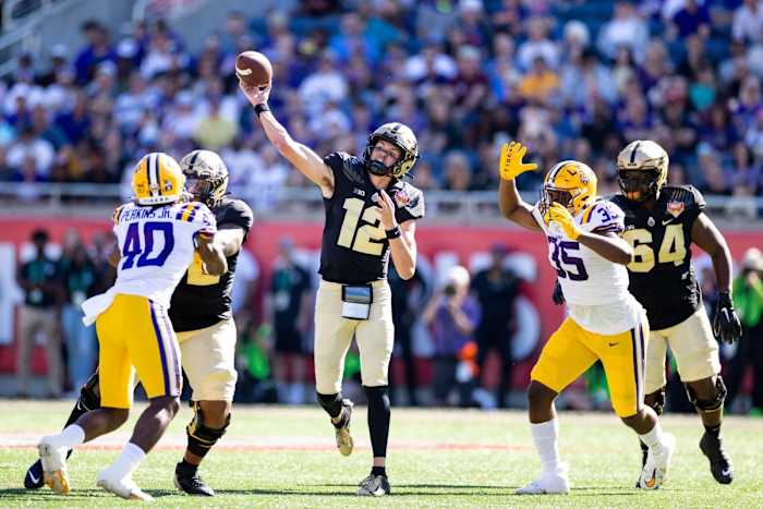 Purdue Boilermakers quarterback Austin Burton (12) throws the ball under pressure from LSU Tigers defensive end Sai'vion Jones (35) and linebacker Harold Perkins Jr. (40) during the first half at Camping World Stadium.