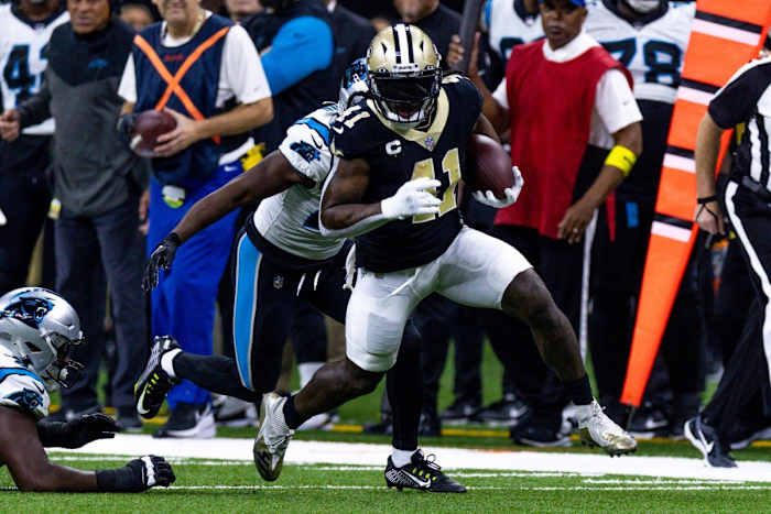 New Orleans Saints running back Alvin Kamara (41) runs through Carolina Panthers defensive tackle Derrick Brown (95) and safety Xavier Woods (25). Mandatory Credit: Stephen Lew-USA TODAY