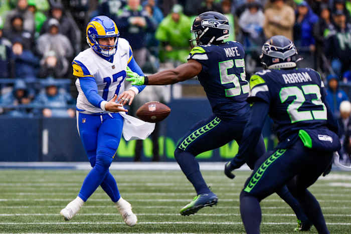 Los Angeles Rams quarterback Baker Mayfield (17) shovel passes as Seattle Seahawks linebacker Boye Mafe applies pressure during the second quarter at Lumen Field.