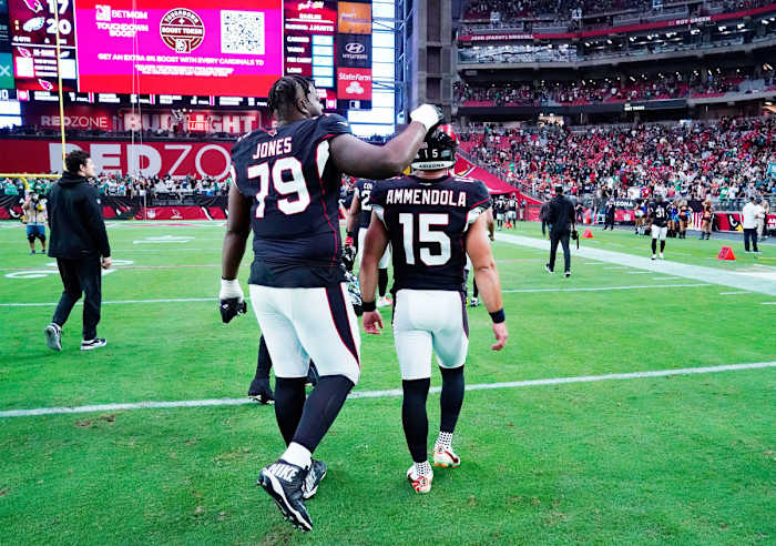 Josh Jones consoles kicker Matt Ammendola as the two leave the field after a Cardinals loss