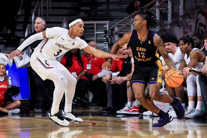 Jan 11, 2023; Cincinnati, Ohio, USA; East Carolina Pirates guard Javon Small (12) controls the ball against Cincinnati Bearcats guard Mika Adams-Woods (3) in the first half at Fifth Third Arena. Mandatory Credit: Aaron Doster-USA TODAY Sports