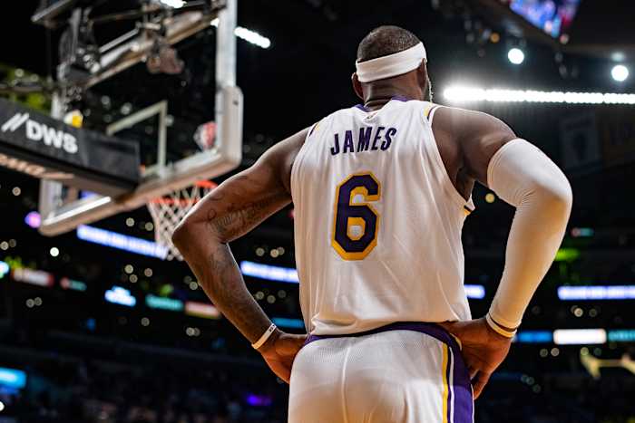 The back of LeBron James, with his name and number on his jersey, as he stands with his hands on his hips
