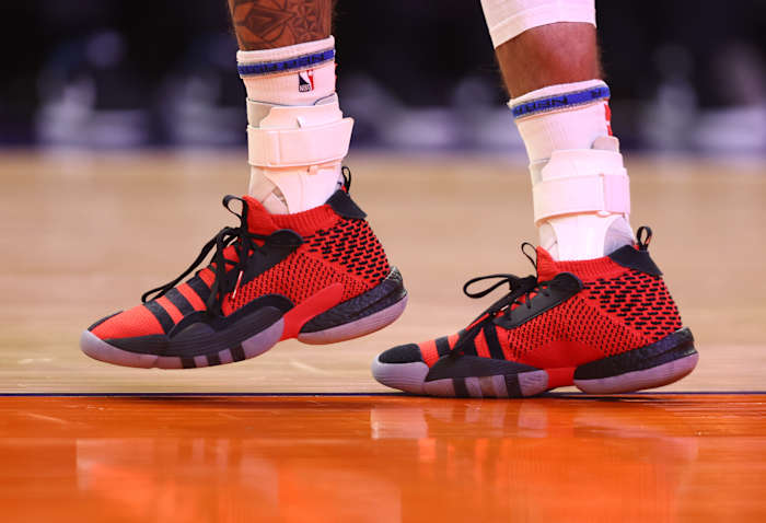 View of Trae Young's red and black adidas shoes.