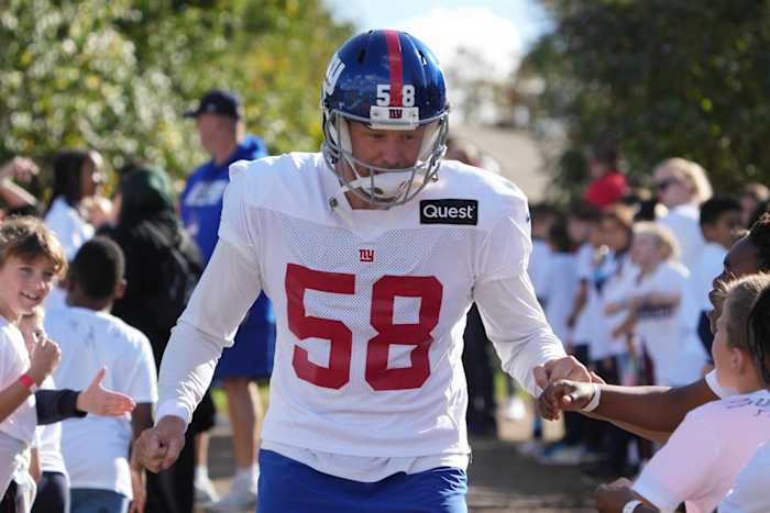 Oct 7,, 2022; Thundridge, United Kingdom; New York Giants long snapper Casey Kreiter (58) is greeted by children during practice at Hanbury Manor.