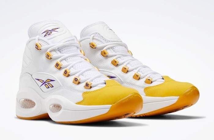 View of white and yellow Reebok shoe.