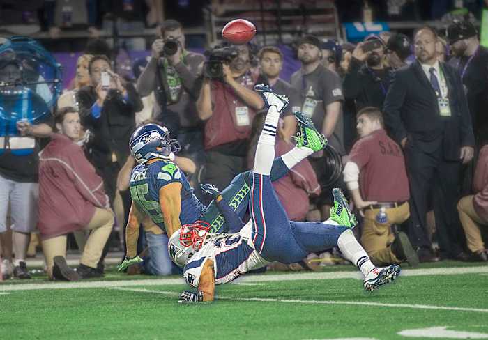 Jermaine Kearse falls alongside Malcolm Butler as he reaches for a catch in the fourth quarter of Super Bowl 49